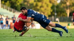 Joueur en rouge plaqué par joueur en bleu au rugby